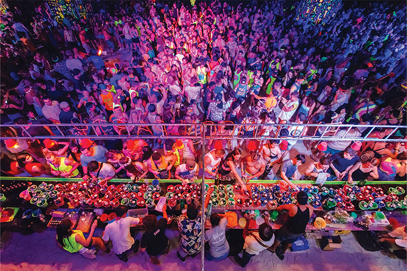 Revellers<br />
line up for their first round of the night—fuel for the long hours ahead.