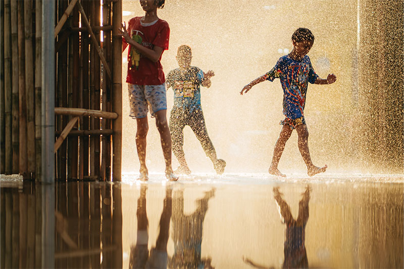 Children use water to cool off from the intense heat.