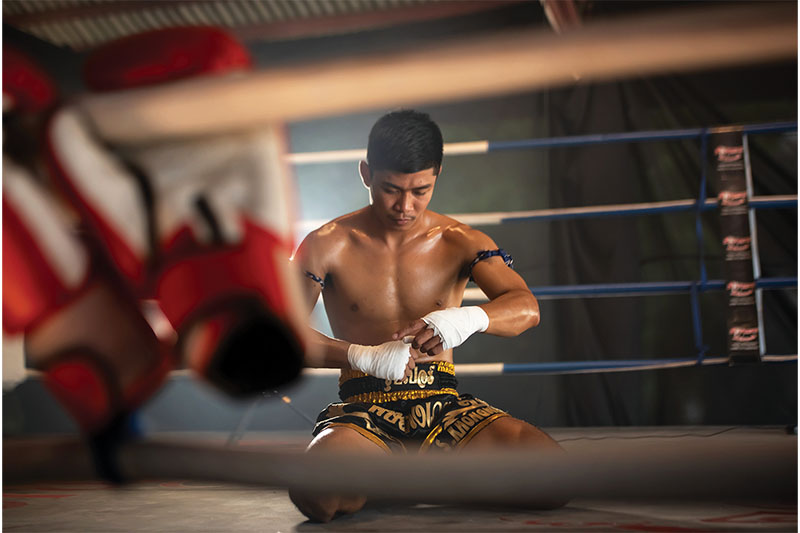 A boxer binds his hands before entering the ring.
